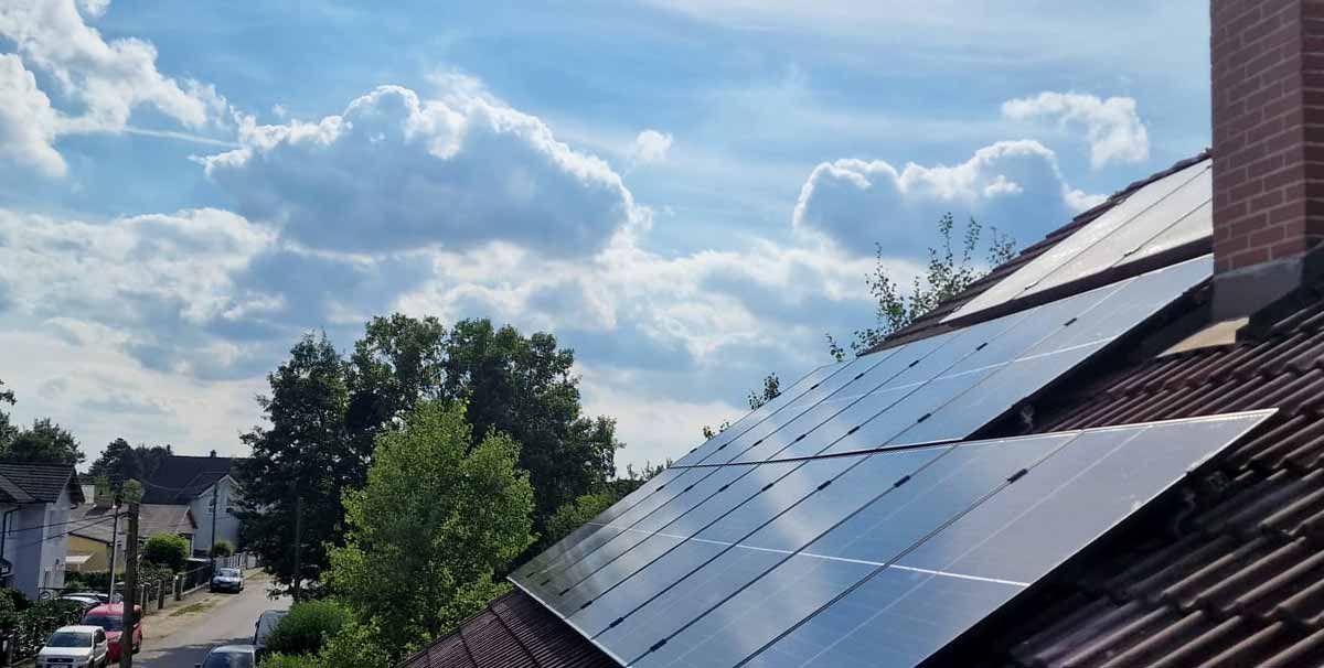 Photovoltaikanlage auf Hausdach und Wolkenhimmel